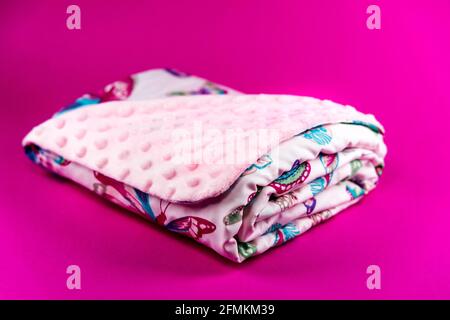 Süße und niedliche rosa Babydecke mit Schmetterlingsmuster isoliert Auf rosa Hintergrund Stockfoto