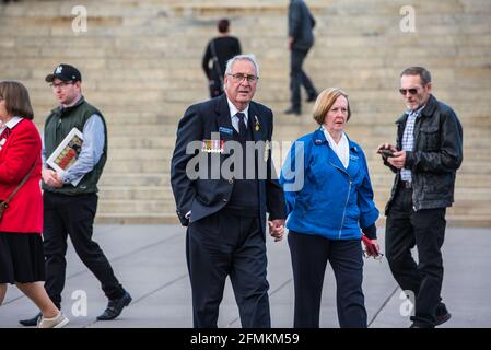 Melbourne, Australien, 09/05/2021, Mr. Grant Knox, Präsident der HMAS Australia Veterans' Association und seine Frau Karen beim Spaziergang über den Shrine of Remembrance Square. „Unsterbliches Regiment“, ein Teil der Feier zum Victory Day am 9. Mai im Memorial „Shrine of Remembrance“ in Melbourne. Der marsch des Unsterblichen Regiments wurde vom russischen Botschafter in Australien und einem ersten Sekretär der russischen Botschaft besucht und ist Teil einer weltweiten Siegesfeier. Menschen mit Fahnen, Transparenten und vor allem Fotos ihrer Familienmitglieder, die im Weltkrieg 2 kämpften, marschierten durch die Straßen von Melbou Stockfoto