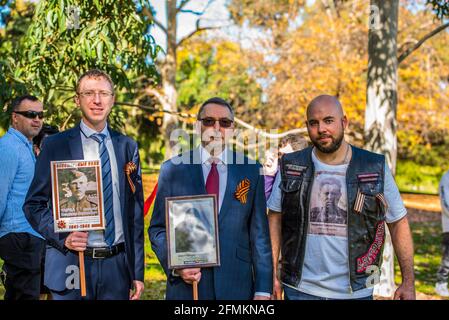 Der russische Botschafter in Australien, Alexey Pavlovsky (C), der erste Sekretär der russischen Botschaft in Australien, Anton Chirva (L), hält zusammen mit einem Mitglied des australischen Motorradclubs der Charta der Nachtwolfen, Stan Gorodyschcher, Fotos ihrer altgedienten Verwandten. „Unsterbliches Regiment“, ein Teil der Feier zum Victory Day am 9. Mai im Memorial „Shrine of Remembrance“ in Melbourne. Der marsch des Unsterblichen Regiments wurde vom russischen Botschafter in Australien und einem ersten Sekretär der russischen Botschaft besucht und ist Teil einer weltweiten Siegesfeier. Menschen mit Fahnen, Transparenten und vor allem Fotos der Stockfoto