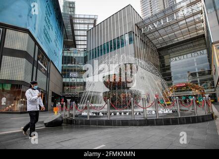 Kuala Lumpur, Malaysia. Mai 2021. Ein Mann mit Gesichtsmaske überprüft sein Mobiltelefon, während er einen leeren Pavillon entlang geht. Der malaysische Premierminister Muhyiddin Yassin hat angekündigt, dass ganz Malaysia aufgrund der steigenden Fälle von Covid-19-Infektionen vom 12. Mai bis 7. Juni 2021 unter den Movement Control Order (MCO) gestellt wird. (Foto von Wong Fok Loy/SOPA Images/Sipa USA) Quelle: SIPA USA/Alamy Live News Stockfoto