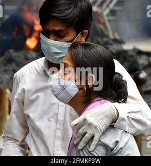 Neu-Delhi, Indien. Mai 2021. Jammere Familienmitglieder trösten sich gegenseitig, nachdem sie die letzten Riten ihrer Angehörigen vorführten, die am 19. Mai 2021 im Nigombodh Ghat Krematorium in Neu-Delhi, Indien, an COVID-10 starben. Quelle: Partha Sarkar/Xinhua/Alamy Live News Stockfoto