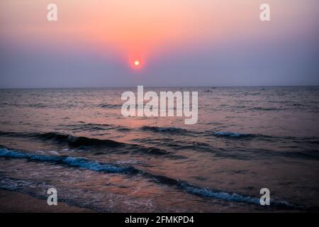 Sonnenaufgang in der Nähe des Strandes mit Booten und Wellen mit Glanz Licht auf die sie Stockfoto