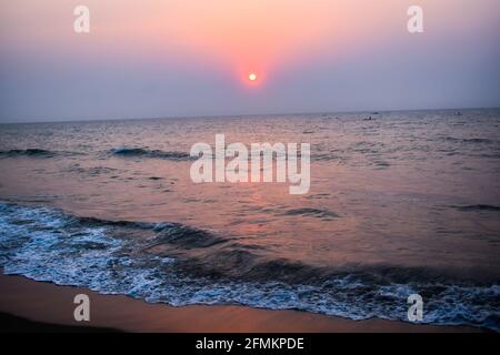 Sonnenaufgang in der Nähe des Strandes mit Booten und Wellen mit Glanz Licht auf die sie Stockfoto