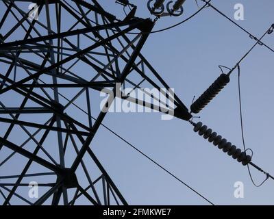 Metalltürme, die die Kupferkabel unterstützen, die Strom transportieren; Türme über dem blauen Himmel: Hochspannungstürme, technische Arbeiten zur Unterstützung der Stockfoto