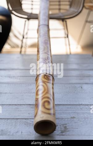 Didgeridoo mit abstraktem Muster auf grauem Tisch dekoriert. Traditionelles australisches Musikinstrument aus Holz Stockfoto