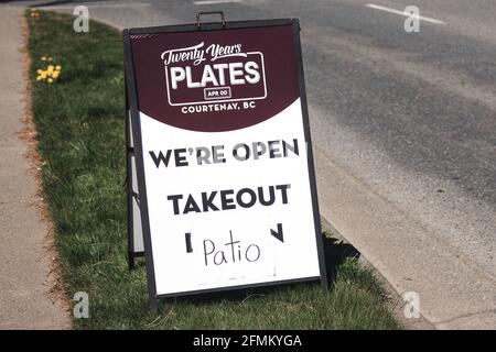 Courtenay, Kanada - 22,2021. April: Blick auf Schild Wir sind wegen COVID-19 am Eingang des lokalen Restaurants in Courtenay geöffnet, nehmen aus, Patio Stockfoto