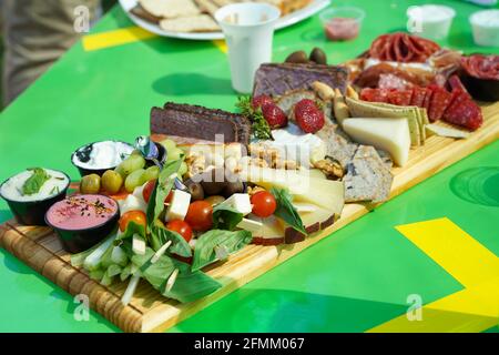 Auswahl an Vorspeisen auf dem grünen Tisch. Auswahl an salzigen, süßen Snacks Stockfoto