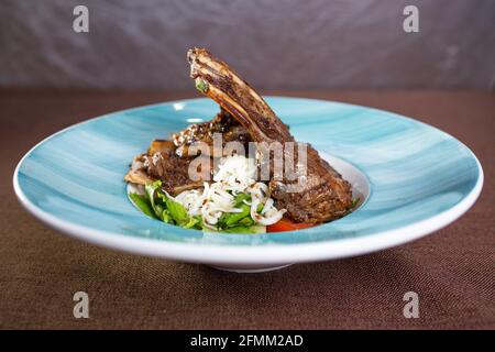 Ein Gericht in einem Restaurant geschmorte Lammrippe mit frischem Salat auf einem Teller. Stockfoto