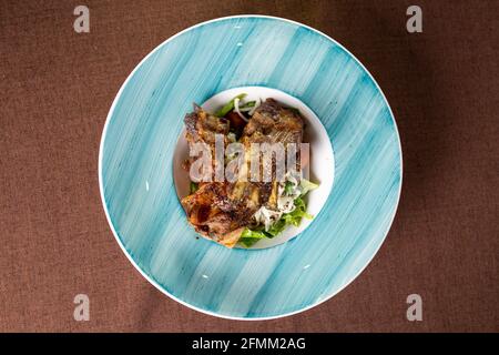 Geschmorte Lammrippe mit frischem Salat auf einem Teller Anzeigen Stockfoto