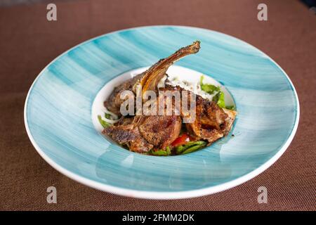 Geschmorte Lammrippe mit frischem Salat auf einem Teller. Stockfoto