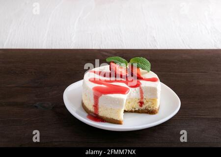 Zweischichtiger Käsekuchen mit frischen Erdbeeren und Beerensirup Stockfoto