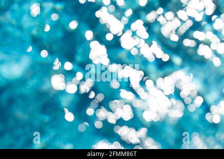 Wellen, Reflexionen, Brechungen und abstrakte Beugungen mit Bokeh-Effekt im blauen und kristallinen Wasser eines Schwimmbades in der Gemeinde Stockfoto