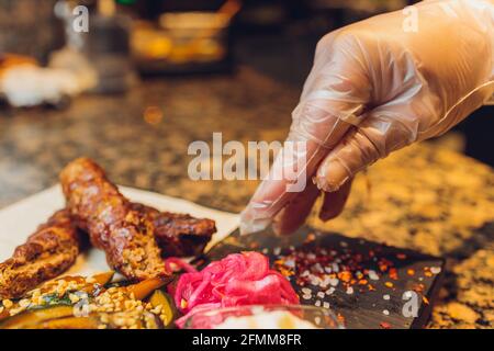 Der Küchenchef bereitet Fleisch auf dem Grill zu Stockfoto