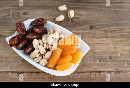 Tablett mit getrockneten Früchten auf einem Holzsockel. Speicherplatz kopieren. Stockfoto