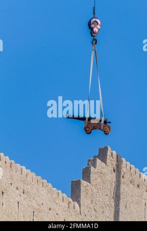 Kran transportiert eine Kanone zum Mutrah Fort in Muscat, Oman Stockfoto