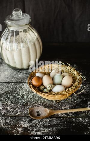 Vertikale Schuss von frischem Huhn und Wachteln Eier in einem Korb auf einem Küchentisch Stockfoto