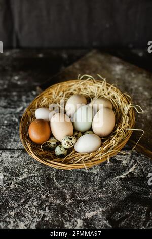 Vertikale Schuss von frischem Huhn und Wachteln Eier in einem Korb Stockfoto