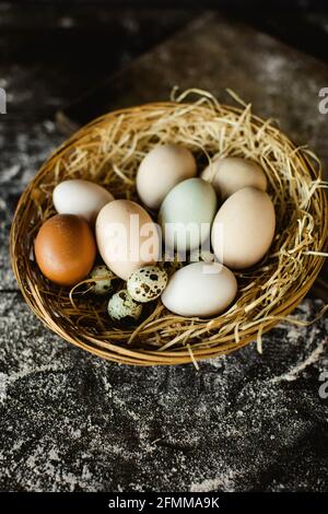 Vertikale Schuss von frischem Huhn und Wachteln Eier in einem Korb Stockfoto