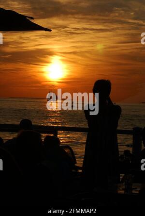 Menschen, die den Sonnenuntergang am Mallory Square in Key West, Florida, USA, beobachten. Stockfoto