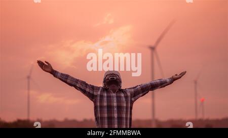 Afrikanische Windmühlen mit weißem Hut, der vor Wind steht Turbine auf Silhouette Sonnenuntergang Stockfoto