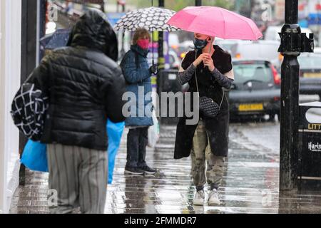 Unter Regenschirmen schützen sich Menschen in London vor Regen. Stockfoto