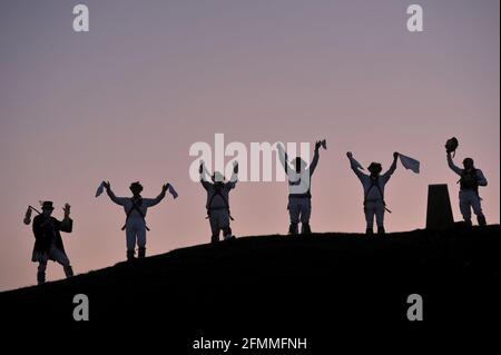 Mit der Regel von sechs in Betrieb und covid Einschränkungen noch an Ort und Stelle Mitglieder von Gloucestershire Morris Männer trafen sich auf Painswick Beacon in der Nähe von Glou Stockfoto