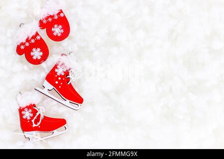 Flache Lay leuchtend rote Weihnachtsmann Kleidung und Skating Schuhe auf weißem künstlichen Schnee Hintergrund mit Kopierraum. Weihnachten und Neujahr Stockfoto