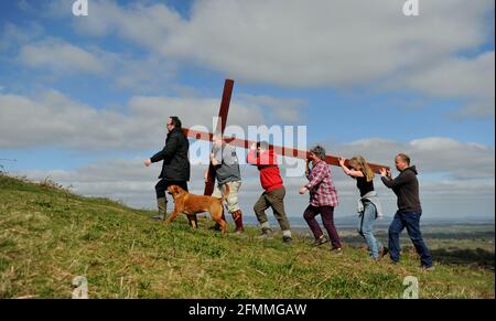 Am Karfreitag vor dem Ostersonntag ein Holzkreuz auf den Cam Peak tragen, bei einem Spaziergang von Witness, Gloucestershire Stockfoto