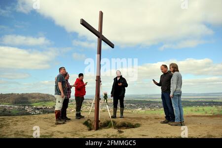 Am Karfreitag vor dem Ostersonntag ein Holzkreuz auf den Cam Peak tragen, bei einem Spaziergang von Witness, Gloucestershire Stockfoto