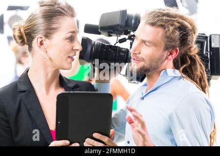 Teamdiskussion oder Regisseur, Kameramann Szene Richtung auf eine video-Produktion für TV oder News geben Stockfoto