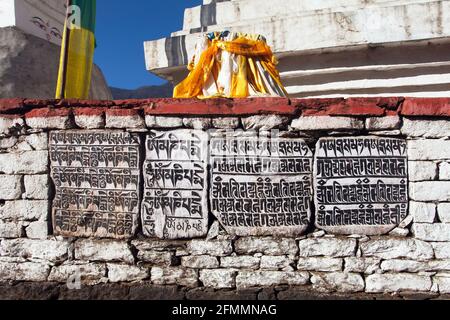 buddhistische Mani-Gebetsmauer auf dem Weg zum Everest-Basislager mit buddhistischen tibetischen Symbolen und Gebetsfahnen, Khumbu-Tal, Sagarmatha-Nationalpark, NEP Stockfoto