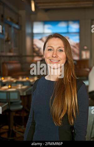 Selbstbewusste Restaurantbesitzerin an ihrer Hipster-Bar in Reykjavik Stockfoto