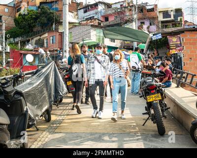 Medellin, Antioquia, Kolumbien - 27 2021. März: Lateinische Touristen mit Gesichtsmasken gehen bei der Tour of Comuna 13 zu Fuß Stockfoto