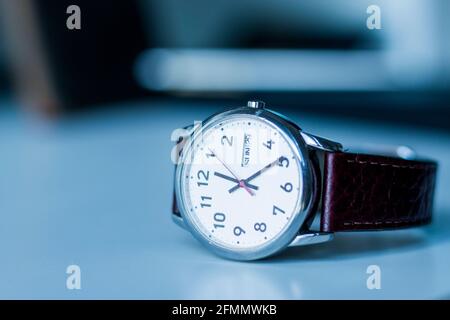 Uhr im Retro-Look mit braunem Lederarmband auf dem Schreibtisch Stockfoto