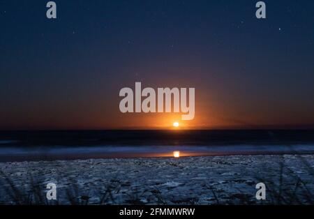 Sonnenaufgang/Mondaufgang über dem Meer an der Gold Coast Stockfoto