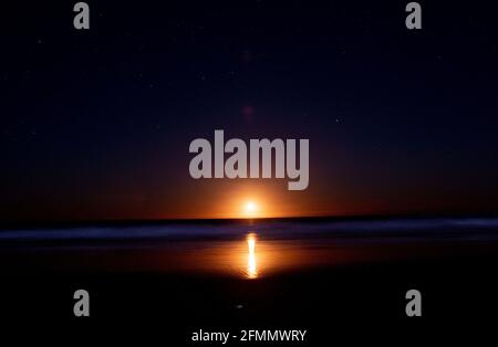 Sonnenaufgang/Mondaufgang über dem Meer an der Gold Coast Stockfoto