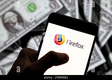 In dieser Abbildung des Open-Source-Webbrowsers, der von der Mozilla Foundation entwickelt wurde, wird das Firefox-Logo auf einem Smartphone mit US-Dollar (USD)-Währung im Hintergrund angezeigt. Stockfoto