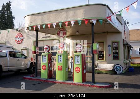 Restaurierter Vintage Flying A Gas Station mit einem Trio von Porzellanpumpen und einer Schaukel auf der Veranda, die jetzt als Motorrad- und ATV-Teile- und Zubehörgeschäft dient... Stockfoto