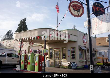 Restaurierter Vintage Flying A Gas Station mit einem Trio von Porzellanpumpen und einer Schaukel auf der Veranda, die jetzt als Motorrad- und ATV-Teile- und Zubehörgeschäft dient... Stockfoto