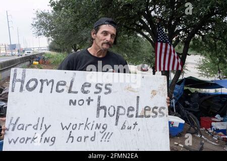 Austin, Texas, USA. Mai 2021. Der Musiker und Handwerker DOUGLAS CRAWFORD hält ein Schild in seinem Lager an der Ecke Ben White Blvd. Und South Congress Avenue in Austin, TX, wo er seit über einem Jahr lebt. Crawford, 60, sagt, er bleibt für sich selbst und macht sich keine Sorgen über die neue obdachlose Niederschlagung von Austin und das Campingverbot ab Dienstag. Quelle: Bob Daemmrich/ZUMA Wire/Alamy Live News Stockfoto