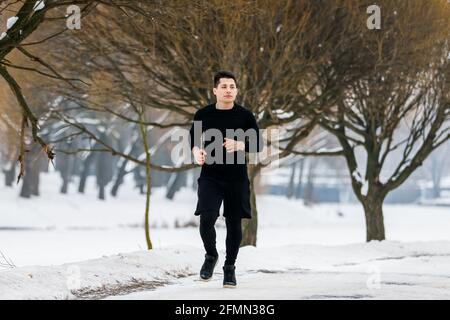 Der junge Mann geht im Winter beim Sport joggen. Stockfoto