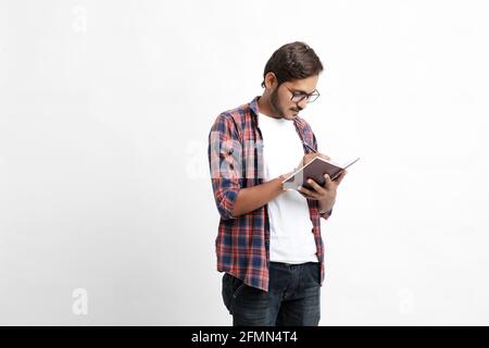 Indische College-Student Buch auf weißem Hintergrund zu lesen. Stockfoto