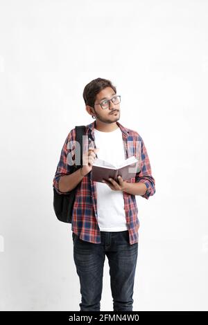 Junge gutaussehende indische College-Student geben Denken Ausdruck auf weiß Hintergrund Stockfoto