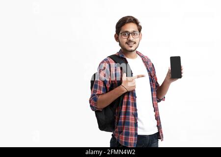 Junge indische College-Student zeigt Smartphone-Bildschirm auf weißem Hintergrund. Stockfoto