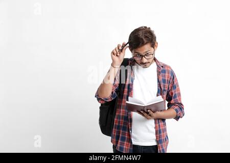Junge gutaussehende indische College-Student geben Denken Ausdruck auf weiß Hintergrund Stockfoto