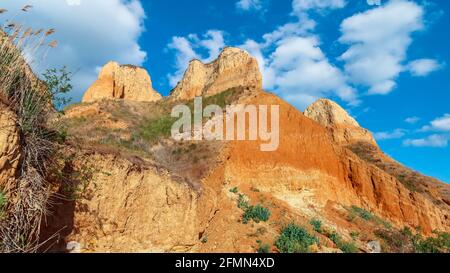 Blick auf die Landschaft von Clay Cape Cliffs. Grünes Gras, Rasenflächen an Hängen von Tonbergen gegen blauen Himmel. Die Hügel der Berge und die Hänge des Kaps sind Stockfoto