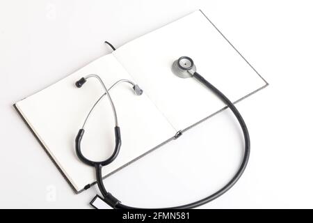 Schwarzes Stethoskop, das auf dem Tagebuch liegt, Medizin. Stockfoto