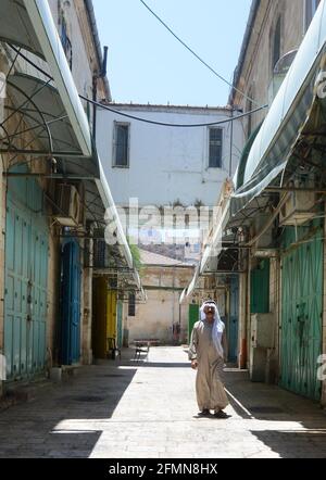 Ein arabischer Mann in traditioneller Kleidung, der im christlichen Viertel der Altstadt Jerusalems unterwegs ist. Stockfoto