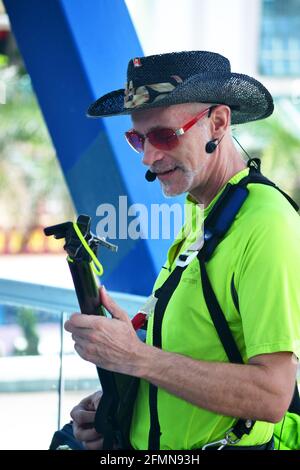 Straßenküchen-Musiker, der in den Straßen Hongkongs Gitarre spielt und Cowboyhut trägt. Stockfoto