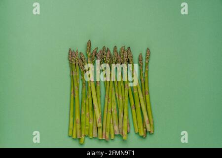 Frische Bio-Spargel-Sprossen auf grünem Hintergrund mit Kopierfläche für Ihr Design. Gesundes Lebensmittelkonzept. Stockfoto